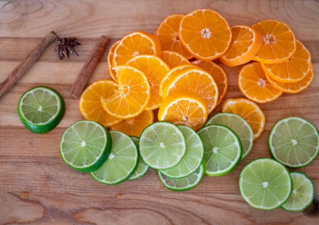 slice oranges and limes for sangria with spices.