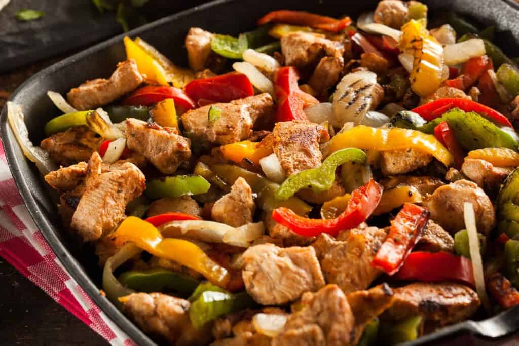 A pan filled with chicken fajitas.