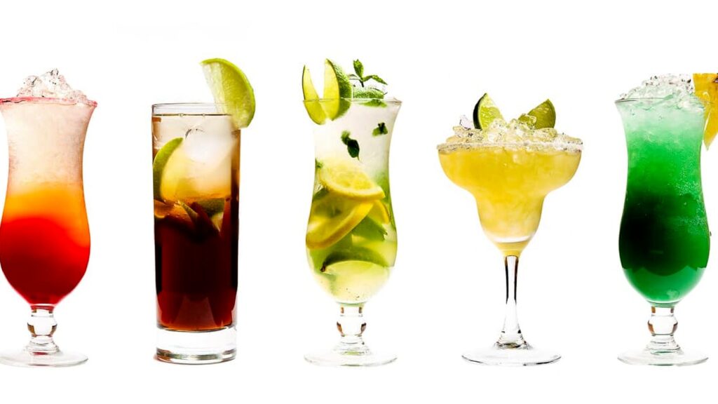 Five colorful cocktails in different glasses, each crafted with premium cocktail mixers and garnished with lime or lemon slices, are filled with ice and displayed against a white background.