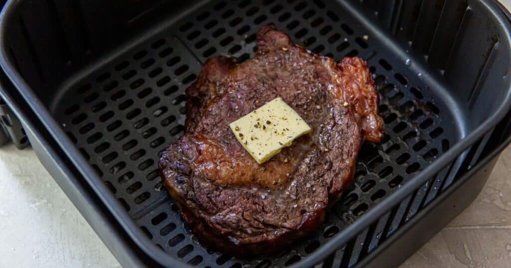 a ribeye cooked in the air fryer topped with butter
