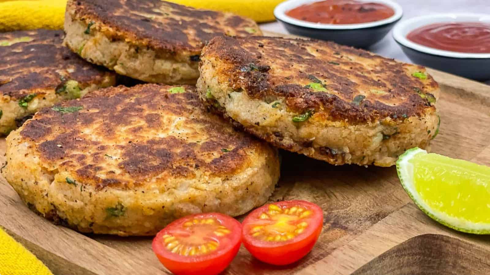 International potato cakes with tomatoes and ketchup on a wooden cutting board.