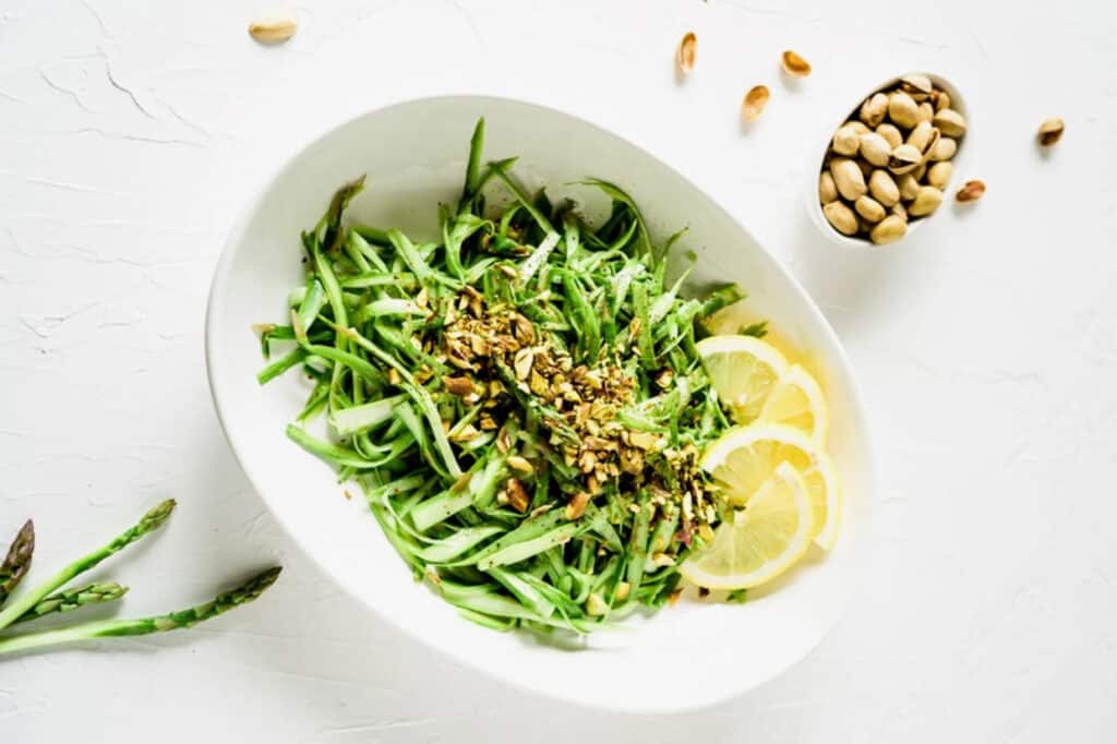 Cold Asparagus Salad with Pistachios in a white bowl.
