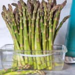 Fresh Asparagus stored in one-inch of water in a glass container.