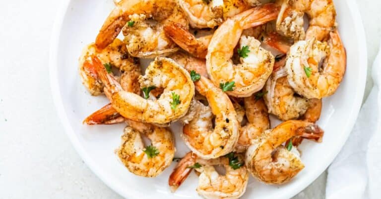 blackstone shrimp topped with parsley on a white plate