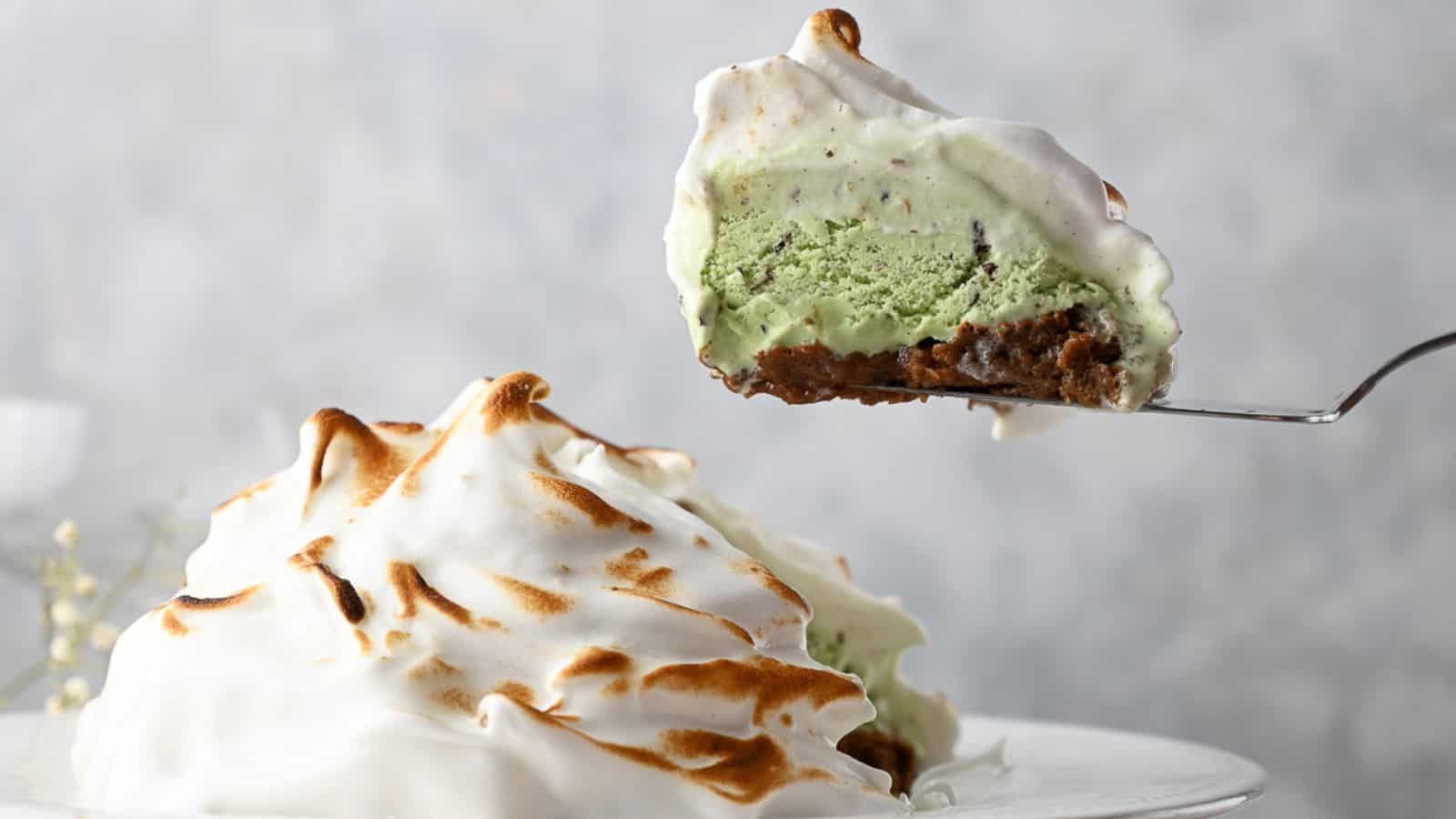 A slice of baked Alaska on a cake slice above the pie with a slice removed.