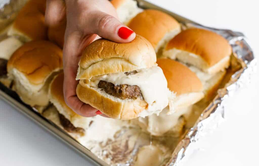 A hand holding a beer slider.