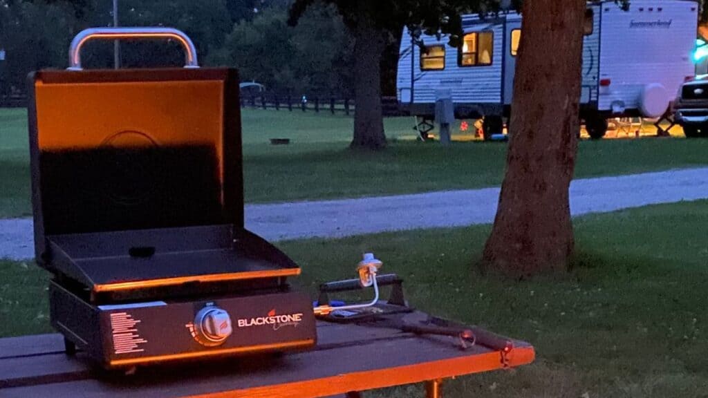 Blackstone Griddle on a picnic table at dusk.