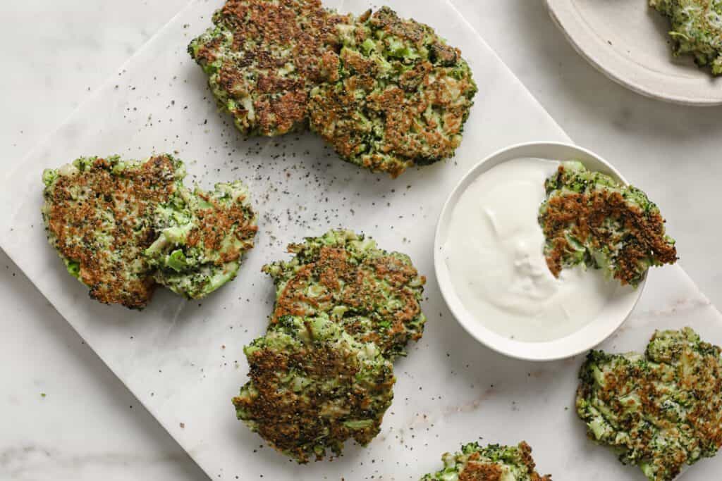 Broccoli Fritters on a white plate with sauce.
