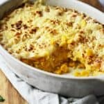 Corn casserole in a casserole dish with a portion removed.