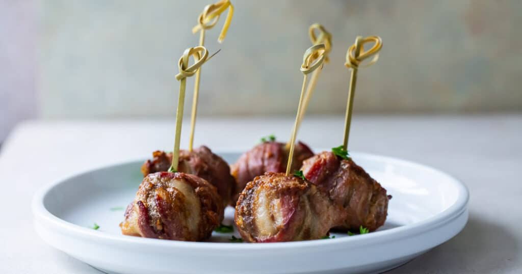 Bacon Wrapped Meatballs on a white plate.