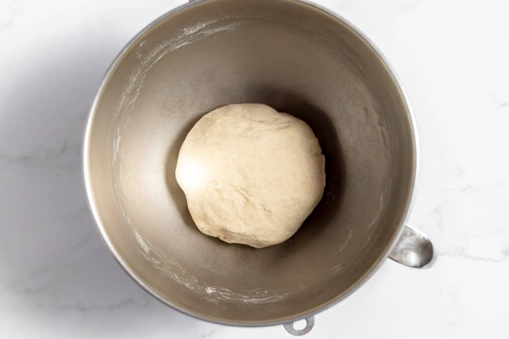 Finished kneaded bread dough in the mixing bowl of a stand mixer. 