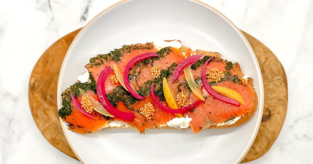 gravlax tartine topped with pickled onion and preserved lemon.