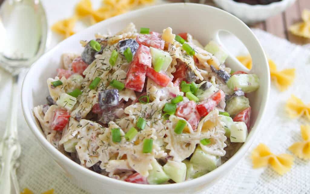 Greek pasta salad in a white bowl.