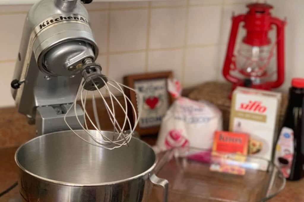 Stainless steel Kitchenaid stand mixer with whisk on a kitchen counter