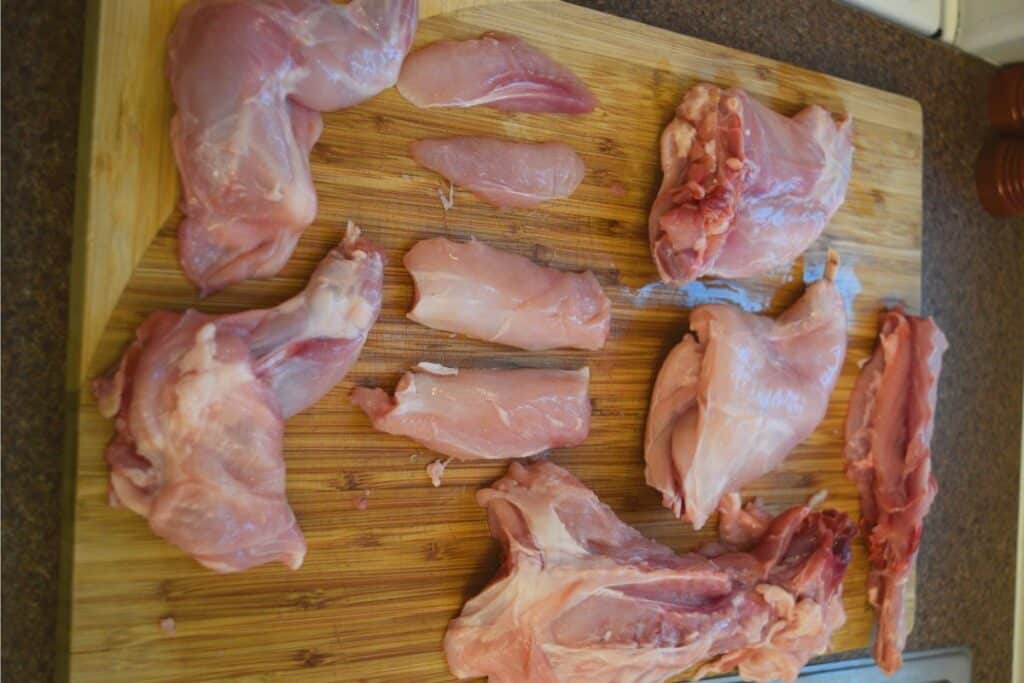 Fresh homestead meats rabbit meat portions on a wooden cutting board.