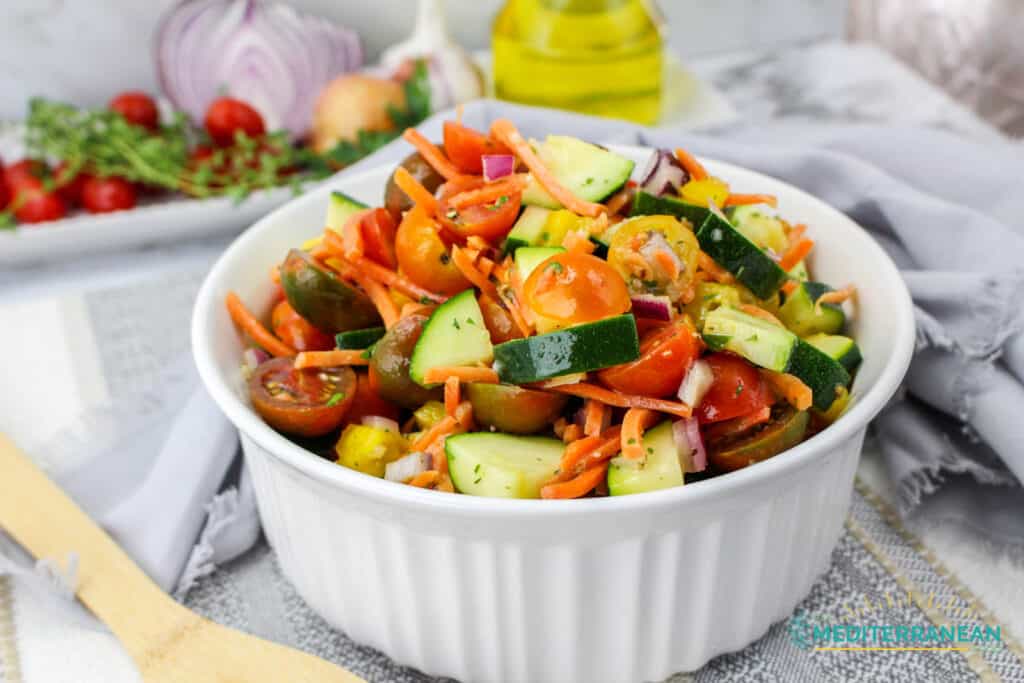 Colorful chopped veggie salad in a white ceramic dish.