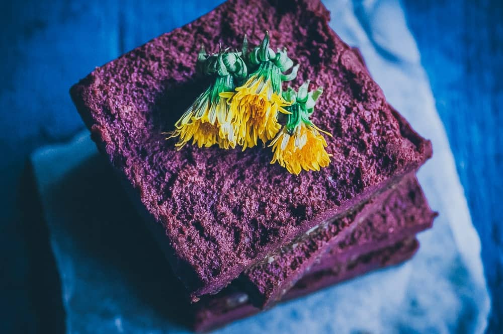 Purple dessert bars garnished with yellow flowers.