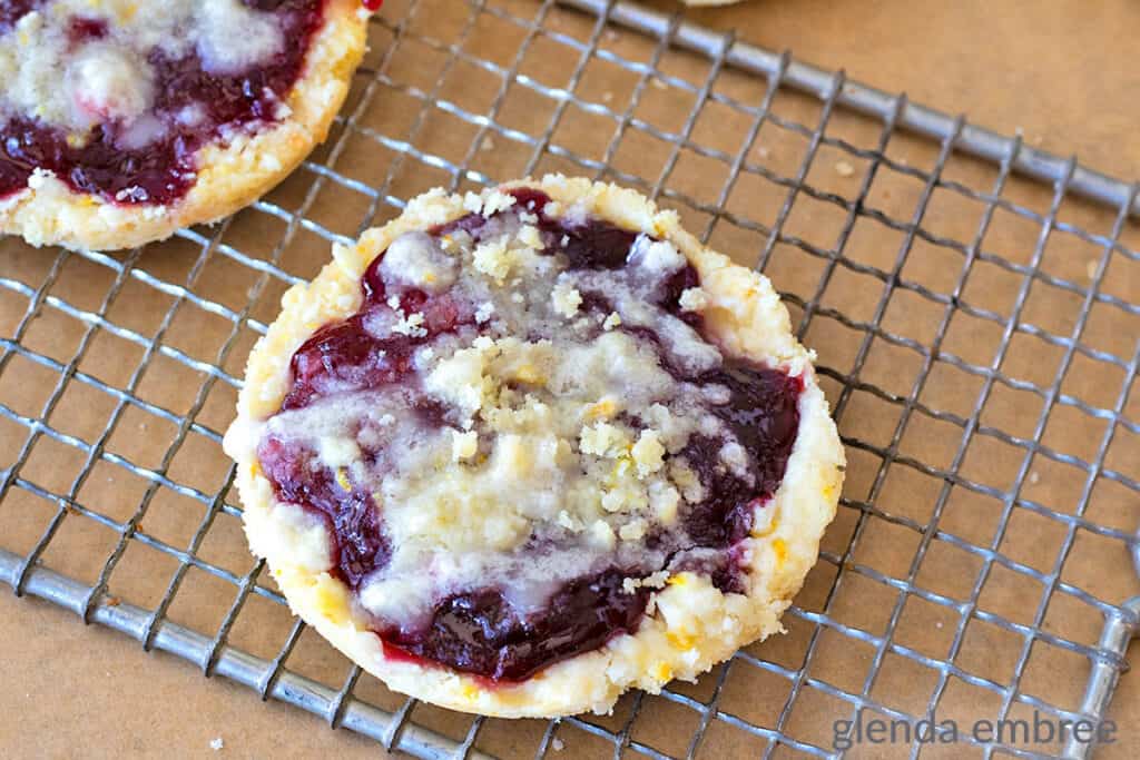 Raspberry Crumble Cookies on a wire cooling rack.  The cooling rack is resting on brown paper.