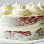 Red Velvet Cake with whipped cream swirls on a cakestand.