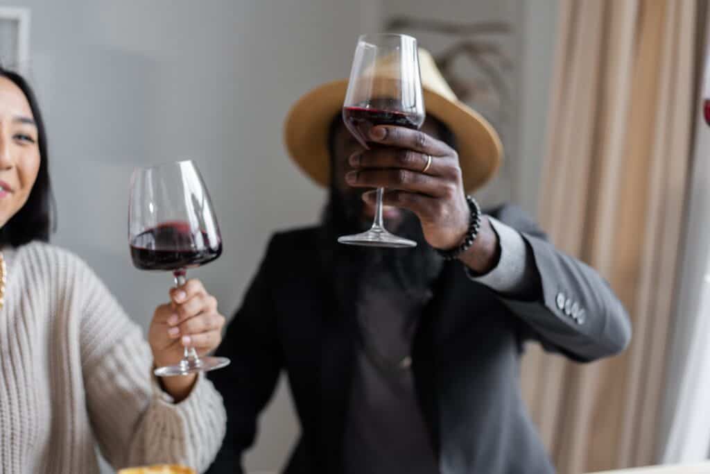 Two people having a toast with red wine.