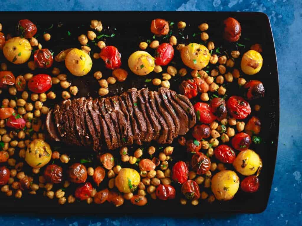 Sheet pan Mediterranean roasted lamb with tomatoes and chickpeas.