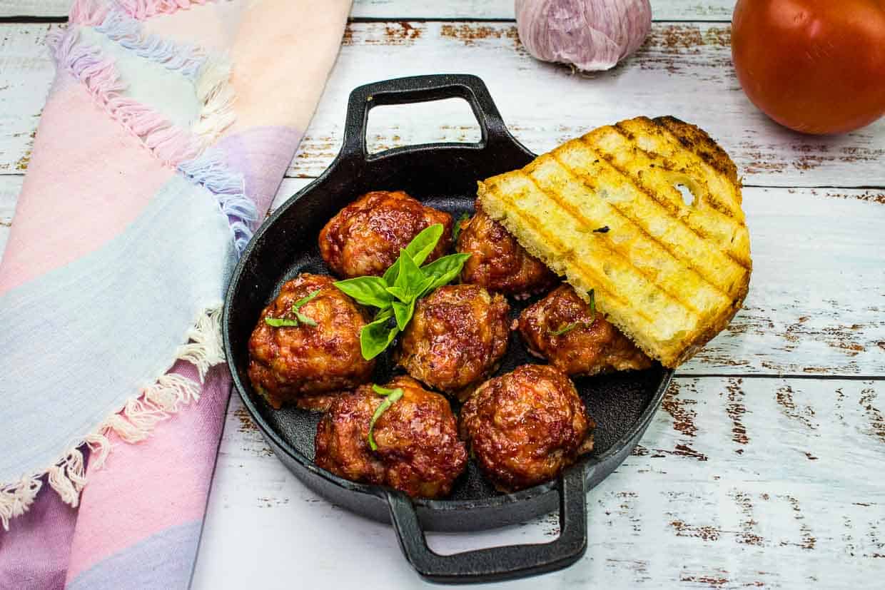 Smoked meatballs in a dish with grilled bread.