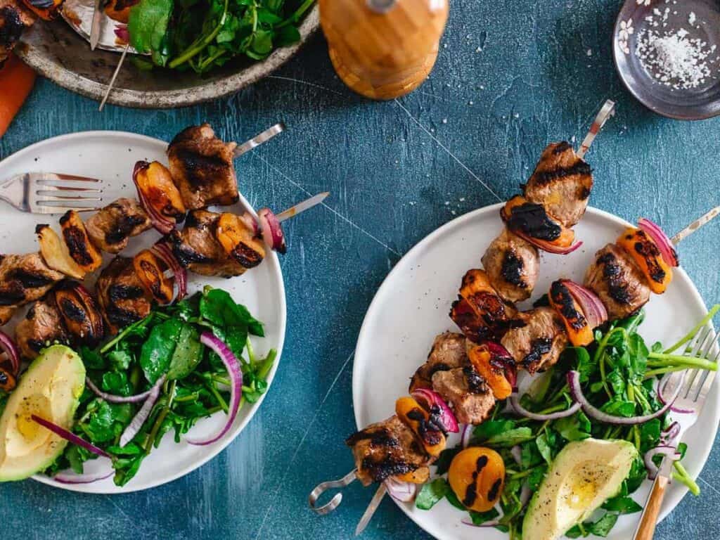 Smoky grilled lamb kebabs with apricots and a side salad.