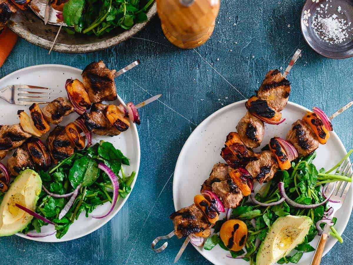 Smoky grilled lamb kebabs with apricots and a side salad.