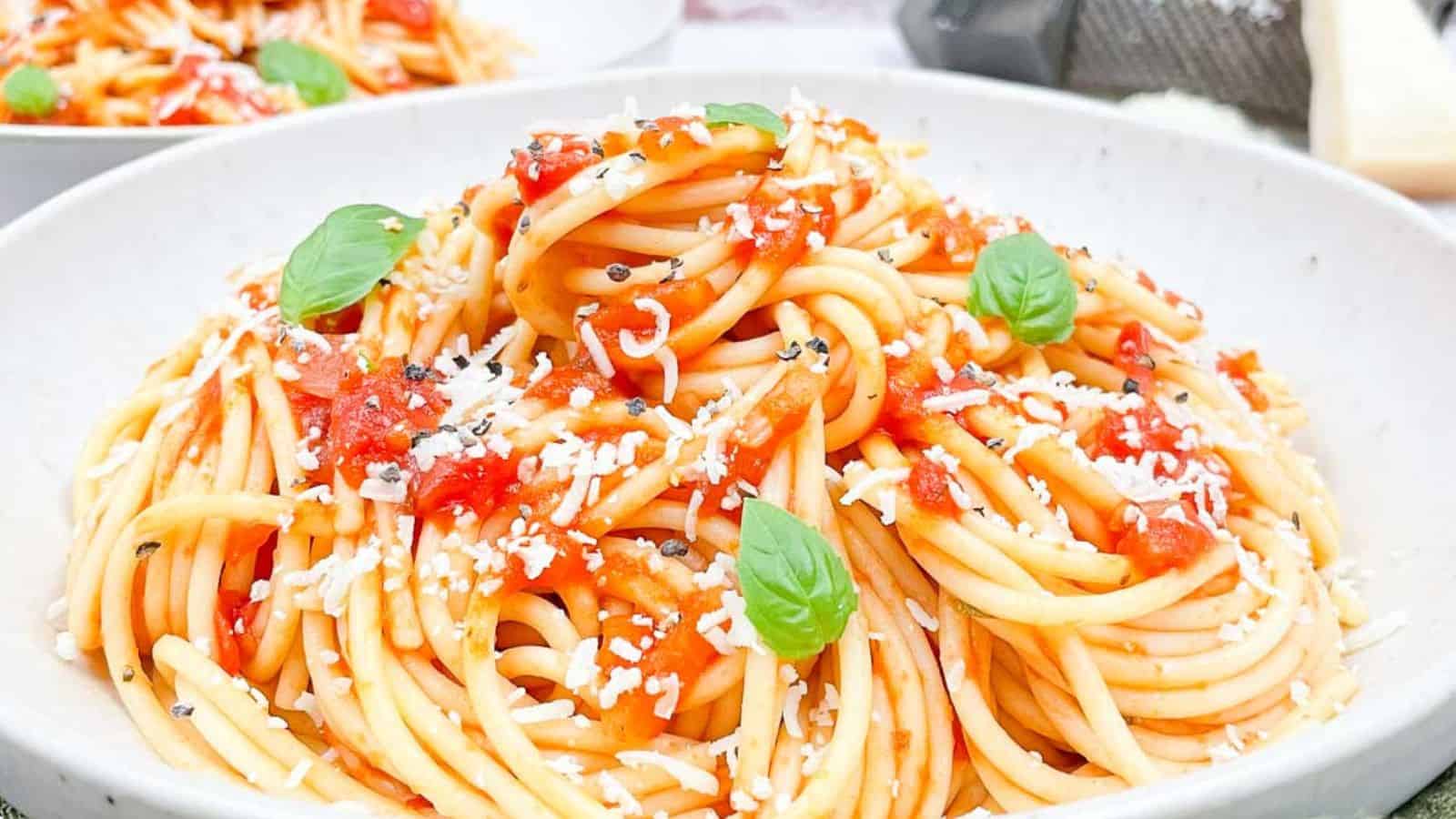 Spaghetti marinara in a bowl with fresh basil on top..