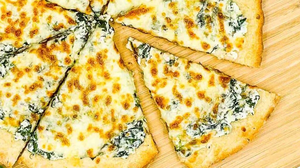 Spinach pizza sliced and ready to eat.
