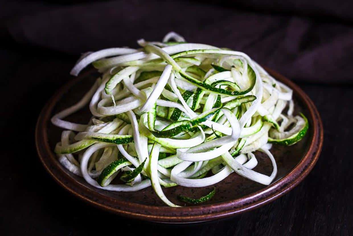 Zucchini noodles on a brown plate.