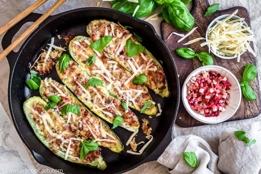 Stuffed zucchini boats in a cast iron skillet.