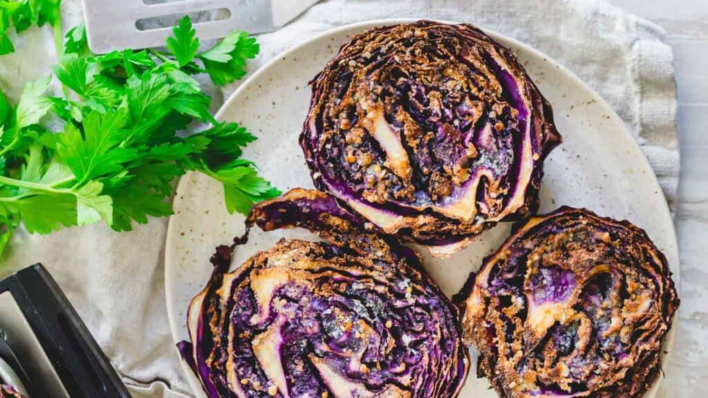 Purple cabbage steaks roasted until crispy in the air fryer on a plate.