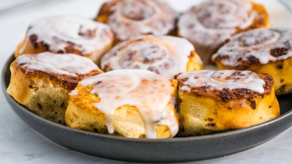 Air Fryer Cinnamon Rolls with frosting on a plate.