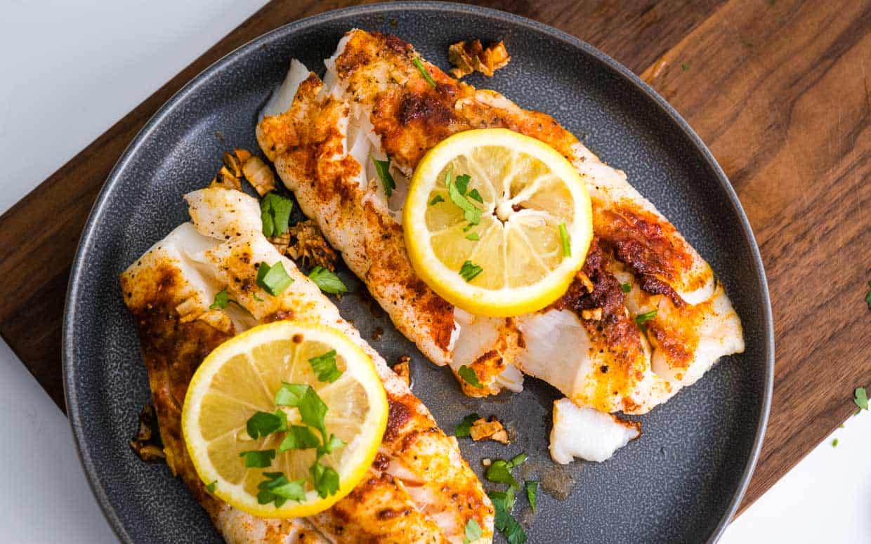 Air fryer cod fillets without breading topped with lemon and herbs.