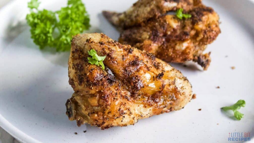 Air fryer chicken wings from frozen on white plate.