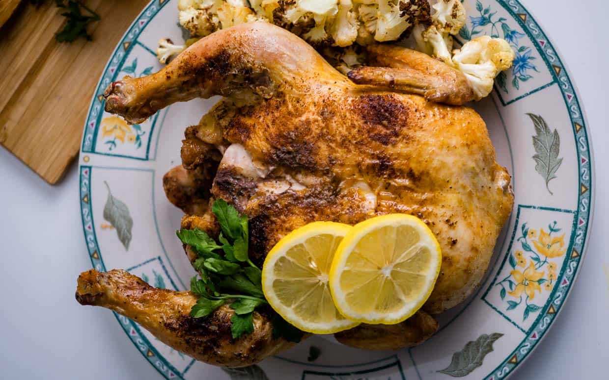 Whole chicken cooked in the air fryer with lemon and herbs.