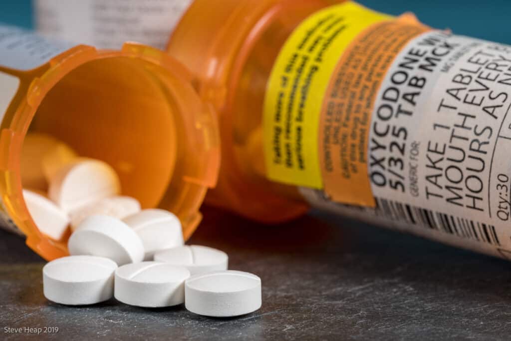 Oxycodone prescription bottle and pills.
