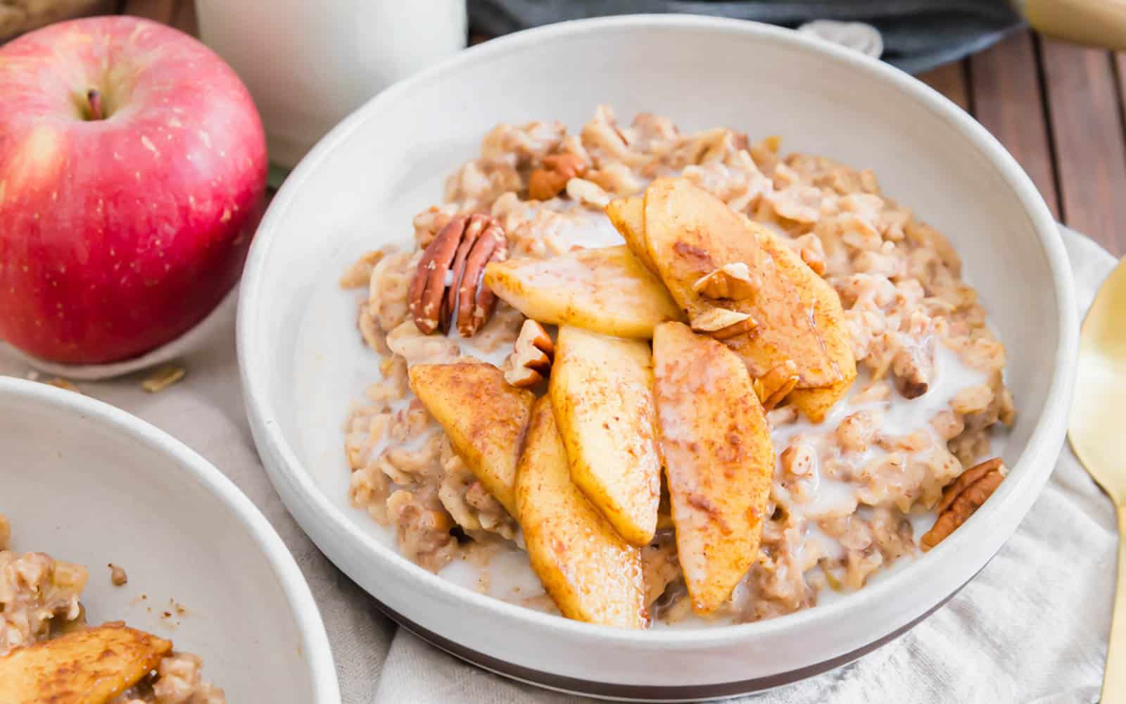Creamy apple cinnamon oatmeal in a bowl with maple apple slices.