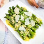 Asparagus with Lemon and Parmesan on a white platter.