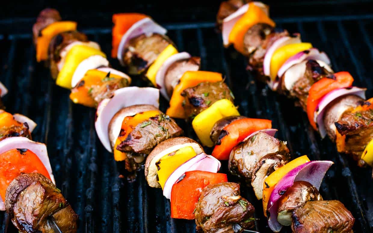 Grilled steak kabobs on a cutting board.