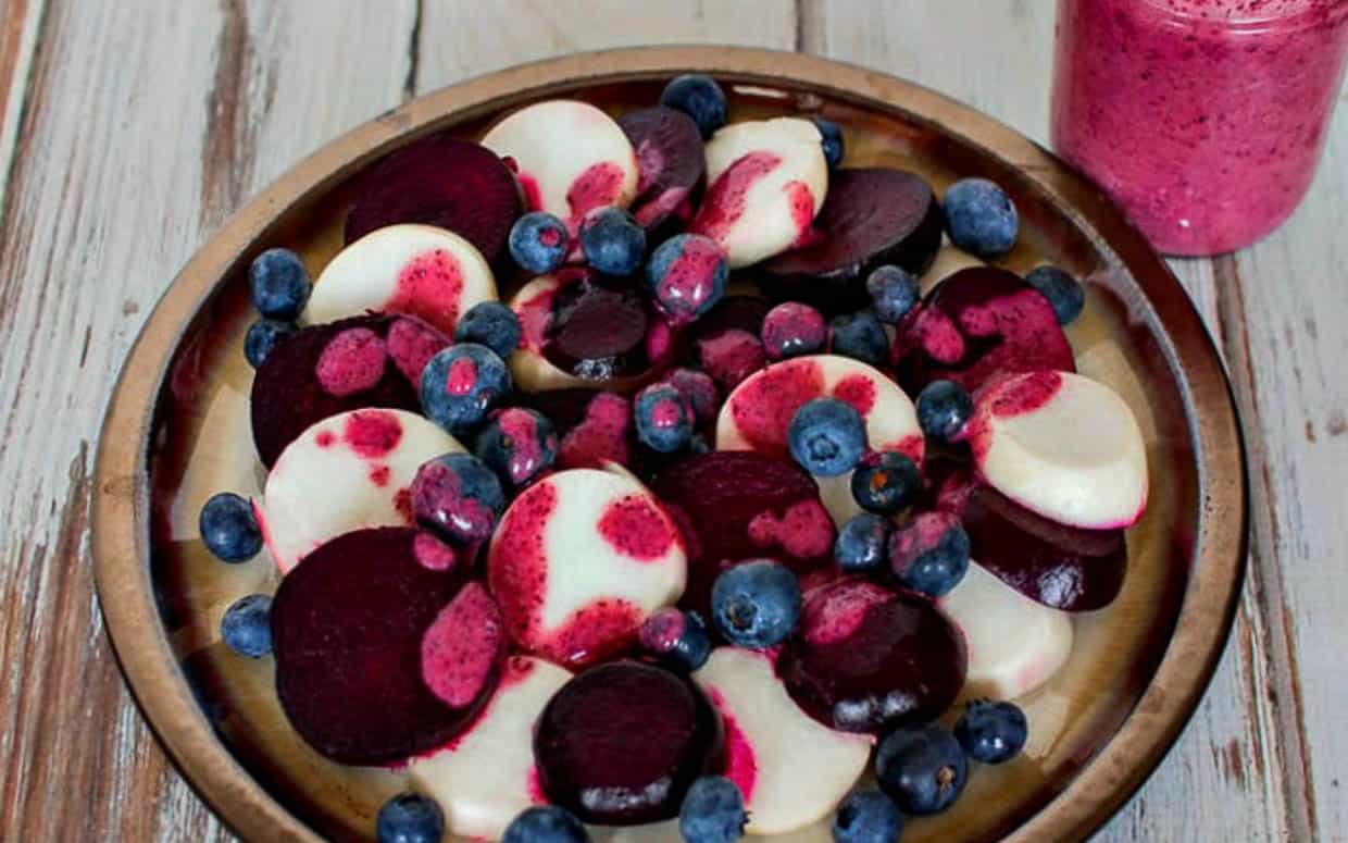 A plate with beets and blueberries on it.