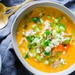 Buffalo chicken soup with orzo served in a bowl with blue cheese crumbles and green onion.