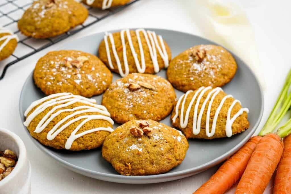 Adorable spring treats featuring carrot cookies adorned with icing and carrots on a plate.
