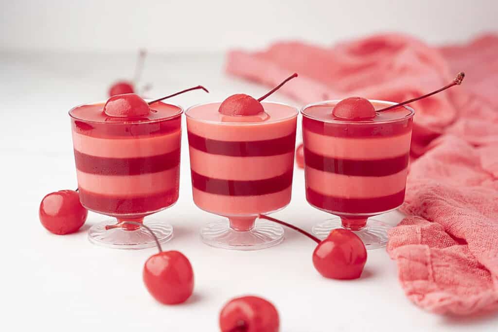 Red and pink layered cherry jello shots.