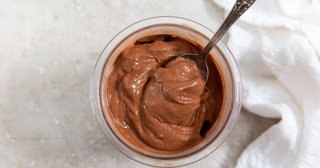 Ninja Creami chocolate protein ice cream in a pint with a spoon.