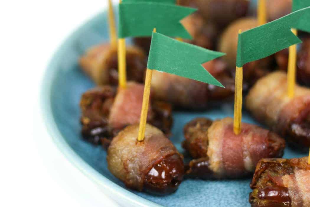 Chorizo Stuffed Bacon Wrapped Dates with green flags. 