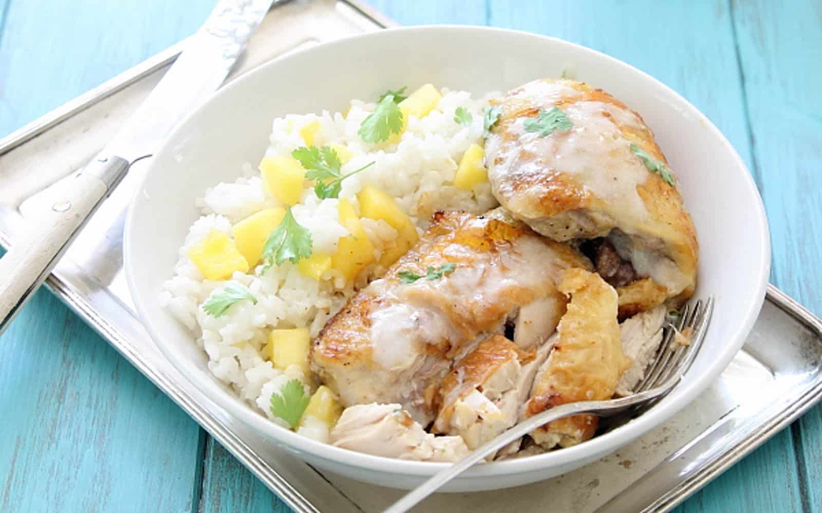 Baked chicken thighs with coconut lime sauce over white rice with mango.