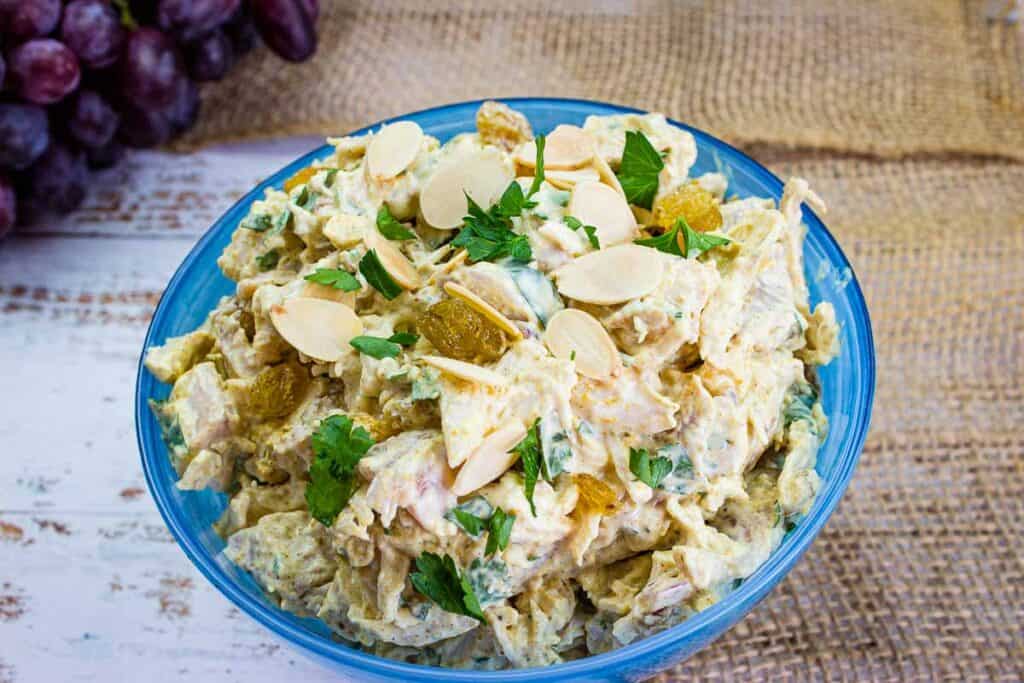 Curried chicken salad in a blue bowl.