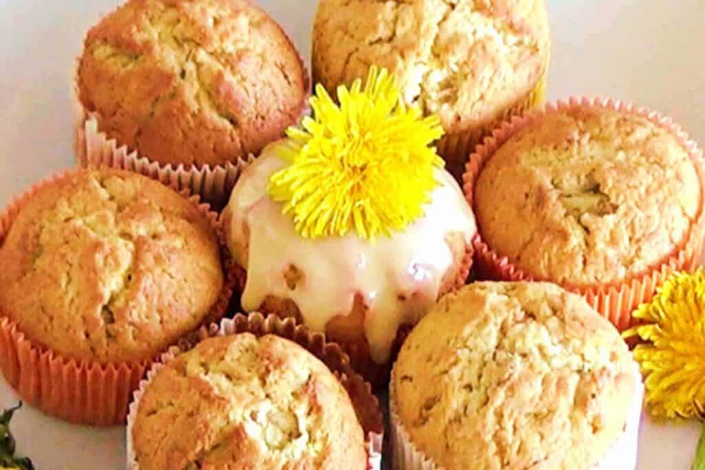 A pile of muffins garnished with yellow flowers.